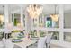 Elegant dining room with a large chandelier and built-in mirrors at 10446 Morning Mist Ln, Sarasota, FL 34241