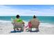 Couple relaxing in beach chairs, enjoying ocean view at 1275 Siesta Bayside Dr # 1275, Sarasota, FL 34242