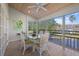 Sunroom with glass walls, wicker dining set and peaceful water view at 1275 Siesta Bayside Dr # 1275, Sarasota, FL 34242