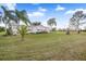 Single-wide mobile home with spacious yard and palm trees at 19990 E State Road 64, Bradenton, FL 34212