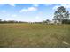 Large grassy yard with a mobile home in the distance at 19990 E State Road 64, Bradenton, FL 34212