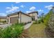 Two-car garage and walkway to the entrance with attractive landscaping at 200 Altamura Cir, Nokomis, FL 34275