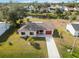 Single-story home with red garage door and landscaped yard at 20096 Tappan Zee Dr, Port Charlotte, FL 33952