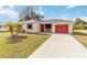 Single story home with red garage door and landscaped lawn at 20096 Tappan Zee Dr, Port Charlotte, FL 33952