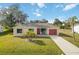 Single story home with red garage door and palm trees at 20096 Tappan Zee Dr, Port Charlotte, FL 33952