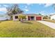 Single-story home with red garage door and palm trees at 20096 Tappan Zee Dr, Port Charlotte, FL 33952