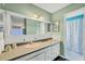 Vintage bathroom with green walls, a large mirror, and a shower with a patterned curtain at 217 46Th W St, Bradenton, FL 34209