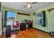 Bright bedroom featuring hardwood floors, a ceiling fan, and a built-in desk space with two windows at 217 46Th W St, Bradenton, FL 34209