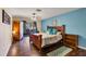 Comfortable main bedroom with blue accent wall, wood floors, and sliding glass door to the exterior at 217 46Th W St, Bradenton, FL 34209
