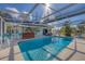 Beautiful pool with a screened-in enclosure, bar, and seating, ideal for enjoying sunny days and outdoor living at 217 46Th W St, Bradenton, FL 34209