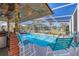 Inviting screened-in pool area with comfortable seating, bar, and a clear view of the surrounding landscape at 217 46Th W St, Bradenton, FL 34209
