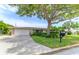 Tan brick ranch house with lush landscaping and large tree in front at 2502 Alpine Ave, Sarasota, FL 34239