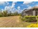 Large grassy backyard with a screened patio area at 26954 Pavin Dr, Englewood, FL 34223