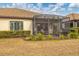 Screened patio with lounge chairs and a well-manicured yard at 26954 Pavin Dr, Englewood, FL 34223