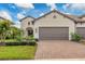 Two-story house with brown garage door and landscaped yard at 26954 Pavin Dr, Englewood, FL 34223