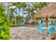 Relaxing poolside seating under a thatched-roof palapa at 26954 Pavin Dr, Englewood, FL 34223