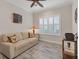 Bright sitting room with a sofa and large window with shutters at 26954 Pavin Dr, Englewood, FL 34223
