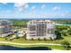 Aerial view of condo building with a pool and waterfront views at 3060 Grand Bay Blvd # 175, Longboat Key, FL 34228