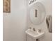 Small bathroom with pedestal sink and round mirror at 3480 Parkridge Cir # 32-103, Sarasota, FL 34243