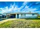Ranch-style home features carport, and a well-manicured lawn at 360 Flamingo Rd, Venice, FL 34293