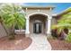 Front entrance with columns, landscaping, and a paved walkway at 3826 E 155Th E Ave, Parrish, FL 34219