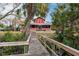 Red house exterior with a wooden walkway leading to the waterfront at 3826 E 155Th E Ave, Parrish, FL 34219