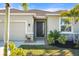 One-story home with a dark brown front door, light beige exterior, and landscaping at 4109 Quiet Rain Ct, Palmetto, FL 34221