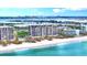 Beautiful waterfront condo building on the white sands of a beach with city views in the background at 415 L Ambiance Dr # A701, Longboat Key, FL 34228