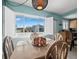 Bright dining area with light wood table, chairs, and ocean views at 475 Benjamin Franklin Dr # 215, Sarasota, FL 34236