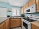 Small kitchen with light wood cabinets and a view of the ocean at 475 Benjamin Franklin Dr # 215, Sarasota, FL 34236