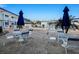 Relaxing pool area with tables and blue umbrellas at 475 Benjamin Franklin Dr # 215, Sarasota, FL 34236