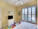 Bedroom with shutters, yellow walls, and a ceiling fan at 4837 88Th E St, Bradenton, FL 34211