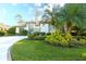 Beautiful front yard with lush green lawn and meticulously maintained tropical landscaping, enhancing curb appeal at 4837 88Th E St, Bradenton, FL 34211