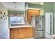 Bright kitchen showcasing wood cabinets, stainless steel refrigerator, and tile flooring at 4837 88Th E St, Bradenton, FL 34211