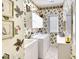 Well-lit laundry room featuring a washer, dryer, sink, storage cabinets, and wallpaper at 4837 88Th E St, Bradenton, FL 34211