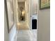 Long hallway with light wood flooring, and framed artwork on the walls at 5324 Popoli Way, Sarasota, FL 34238