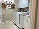 Bright laundry room with washer, dryer, cabinets, and countertop at 5324 Popoli Way, Sarasota, FL 34238