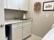 Laundry room with white cabinets, granite countertop, and a utility sink at 5324 Popoli Way, Sarasota, FL 34238