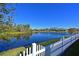 White picket fence and lake view from the backyard at 5522 69Th E Pl, Ellenton, FL 34222