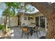 Peaceful patio with a bistro set under a large tree at 6005 Midnight Pass Rd # N8, Sarasota, FL 34242