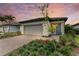 Single-story home with gray garage door, landscaping, and paver driveway at 6273 Winding Pine Dr, Nokomis, FL 34275