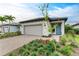 Single-story home with gray garage door, landscaping, and paver driveway at 6273 Winding Pine Dr, Nokomis, FL 34275