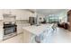 Modern kitchen with white cabinets, large island and stainless steel appliances at 6273 Winding Pine Dr, Nokomis, FL 34275