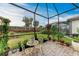 Relaxing screened patio with seating area, lush landscaping and brick pavers at 6273 Winding Pine Dr, Nokomis, FL 34275