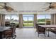 Bright screened porch with water views, wicker furniture, and large windows at 7056 Hawks Harbor Cir, Bradenton, FL 34207