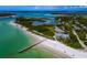Aerial view of beachfront property with private pier and lush landscape at 711 Russell St, Longboat Key, FL 34228