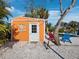 Bright orange storage shed with white door and sun design at 711 Russell St, Longboat Key, FL 34228