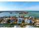 Stunning aerial view of waterfront home with pool, dock, and boat lift in a beautiful coastal community at 718 Key Royale Dr, Holmes Beach, FL 34217