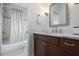 This tiled bathroom includes a tub and shower combo and dark cabinets providing a warm inviting feeling at 718 Key Royale Dr, Holmes Beach, FL 34217