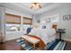 A cozy bedroom featuring hardwood floors, two windows with beach views and a queen sized bed with blue accents at 718 Key Royale Dr, Holmes Beach, FL 34217
